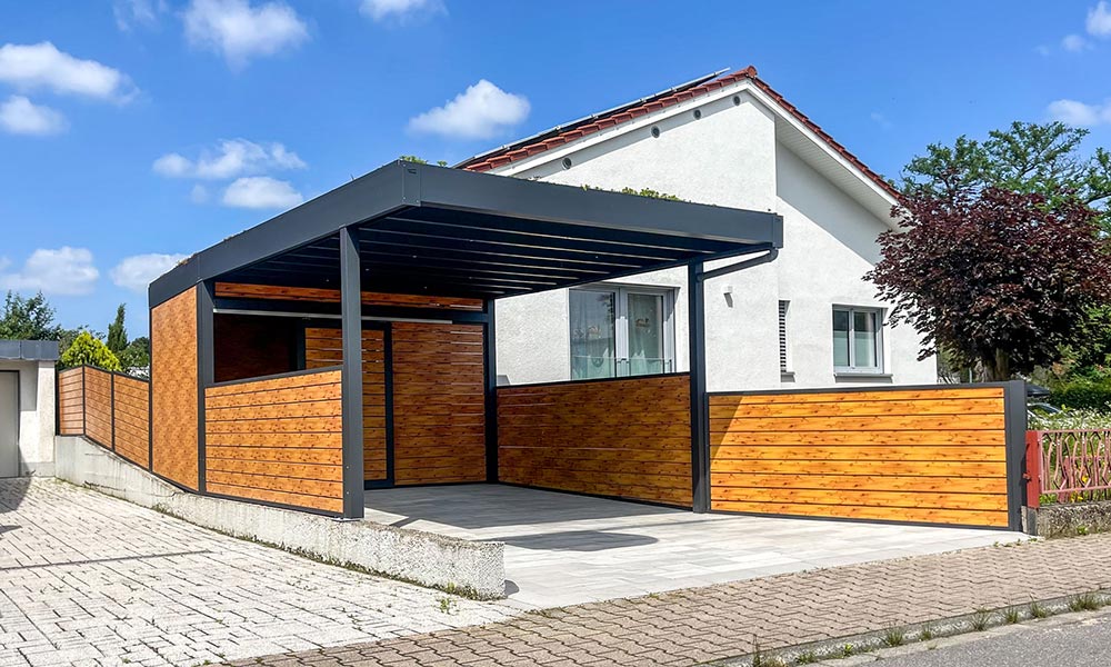 Moderner Carport mit dunklem Metallrahmen und warmen Holzelementen vor hellem Haus